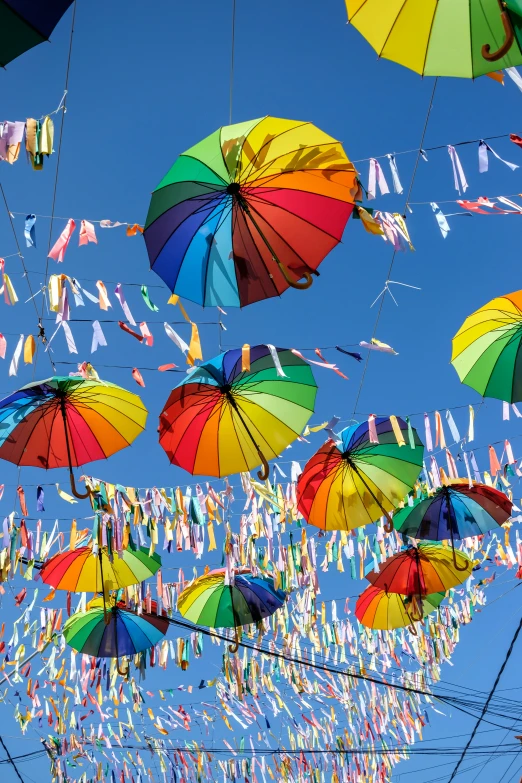 many colorful umbrellas suspended from wires that are not in use