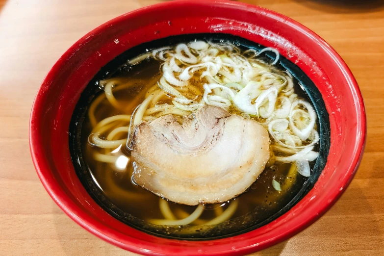 a bowl of asian noodle soup is shown with the meat in it