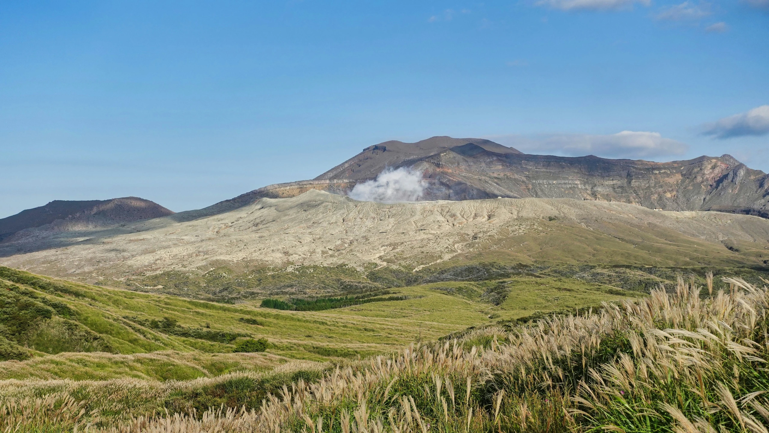 a large mountain on top of a hill covered in grass