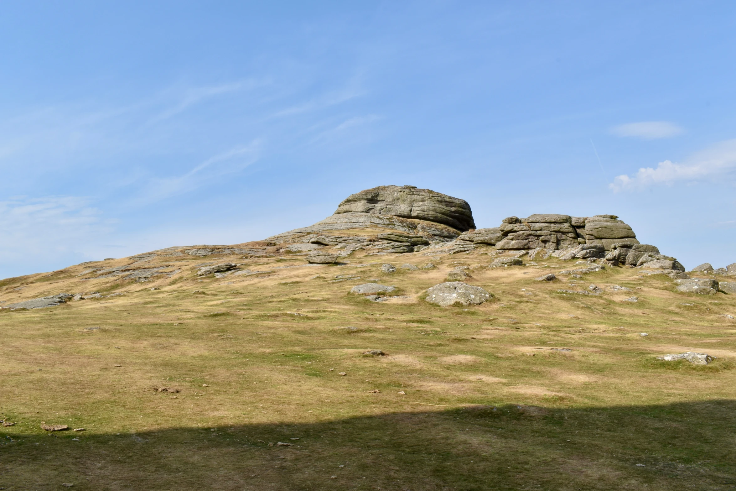 a lone sheep sits atop the mountain