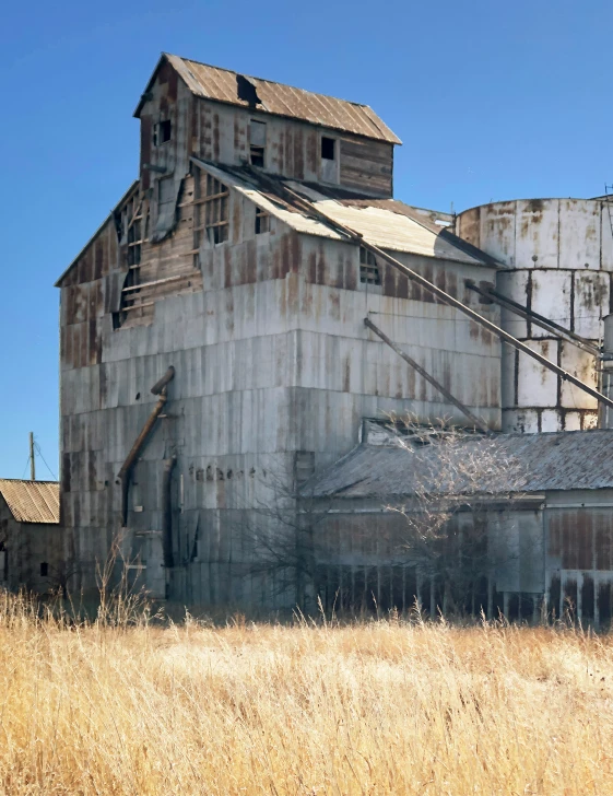 there is a large grain mill in the middle of an open field
