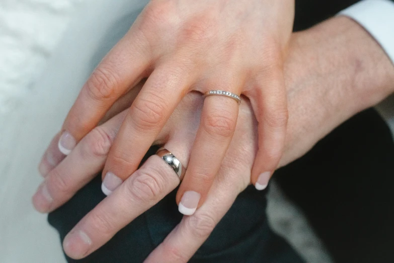 a person's hand in a suit is shown with a diamond ring