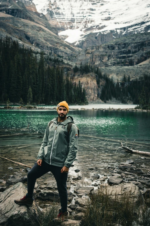 the man stands on a mountain overlooking a lake