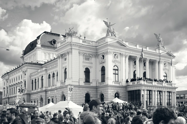 some people are standing outside of a very large building