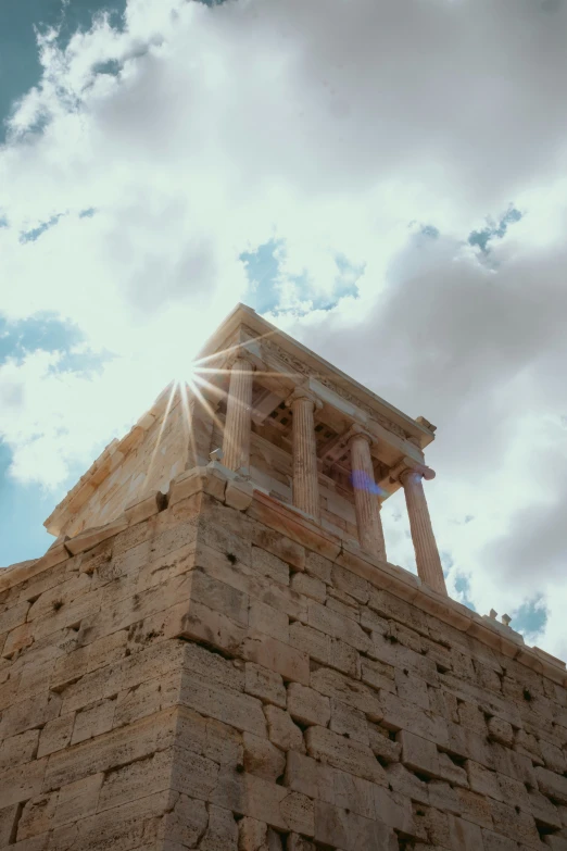 an old style stone tower with pillars under the sun