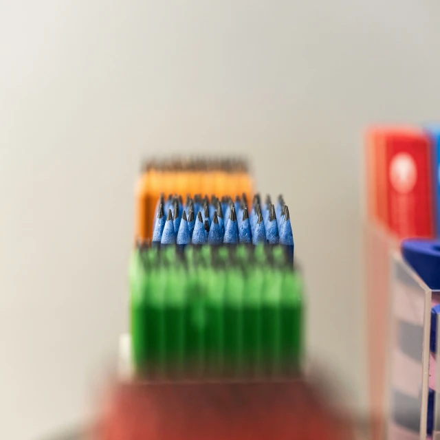 three multicolored tooth brushes are stacked together