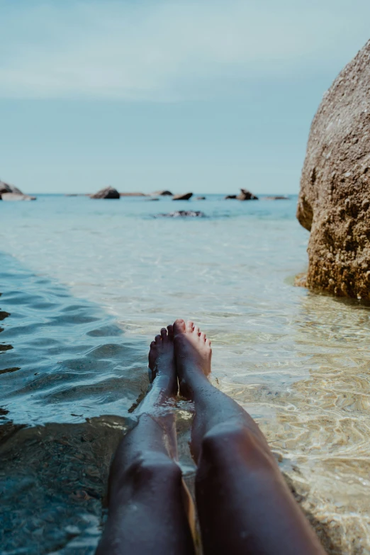 a person relaxing at a beach by rocks