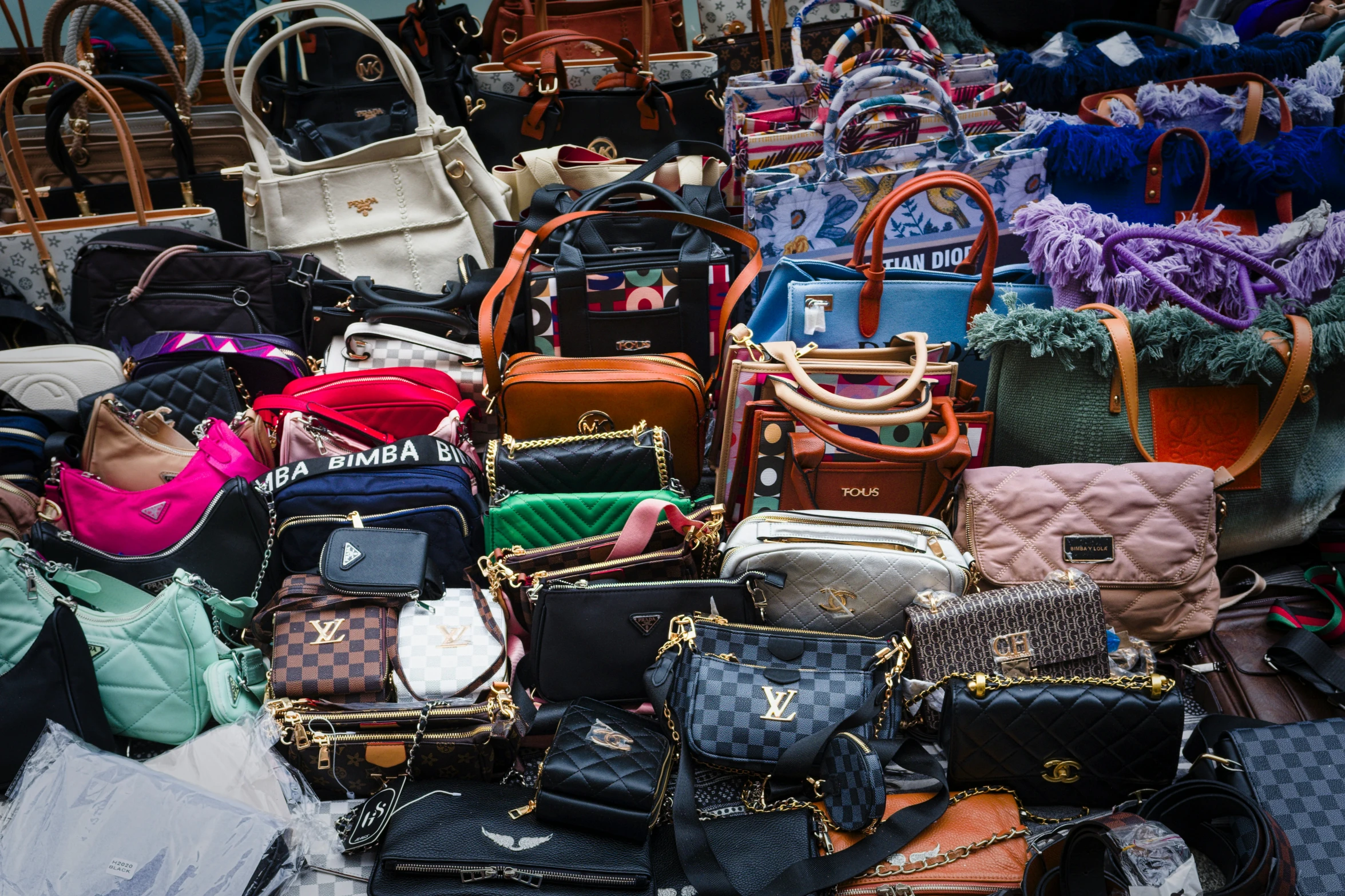 bags with different patterns and designs are piled on top of each other