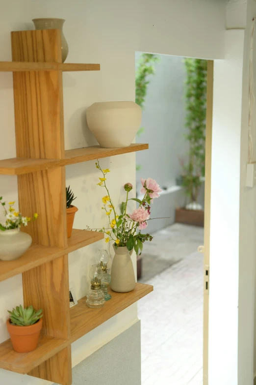 vases and flowers are on the shelves in the room