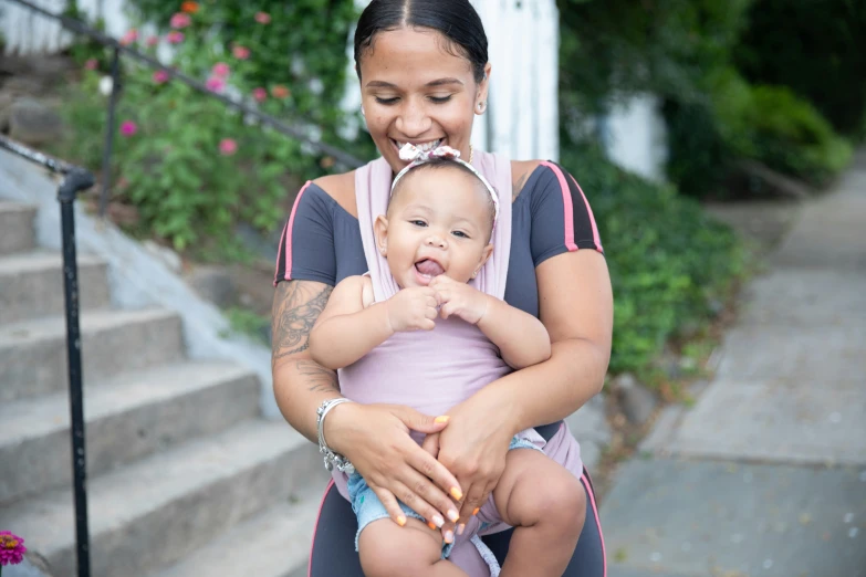 a woman holds her child on the front steps