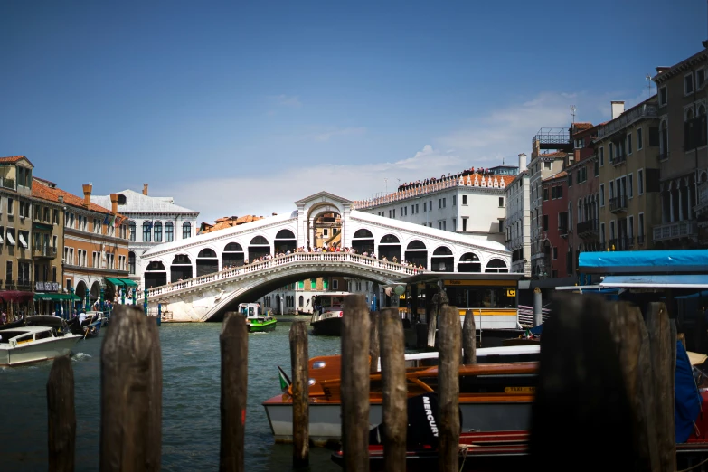 a bridge is above water near some buildings