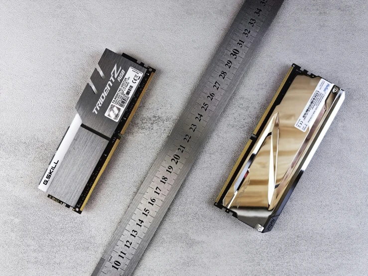 the side view of a gold, metal razor blade with the ruler