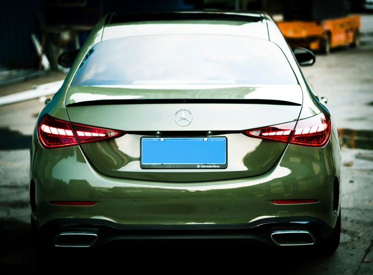 back view of car parked in lot with yellow garbage bin