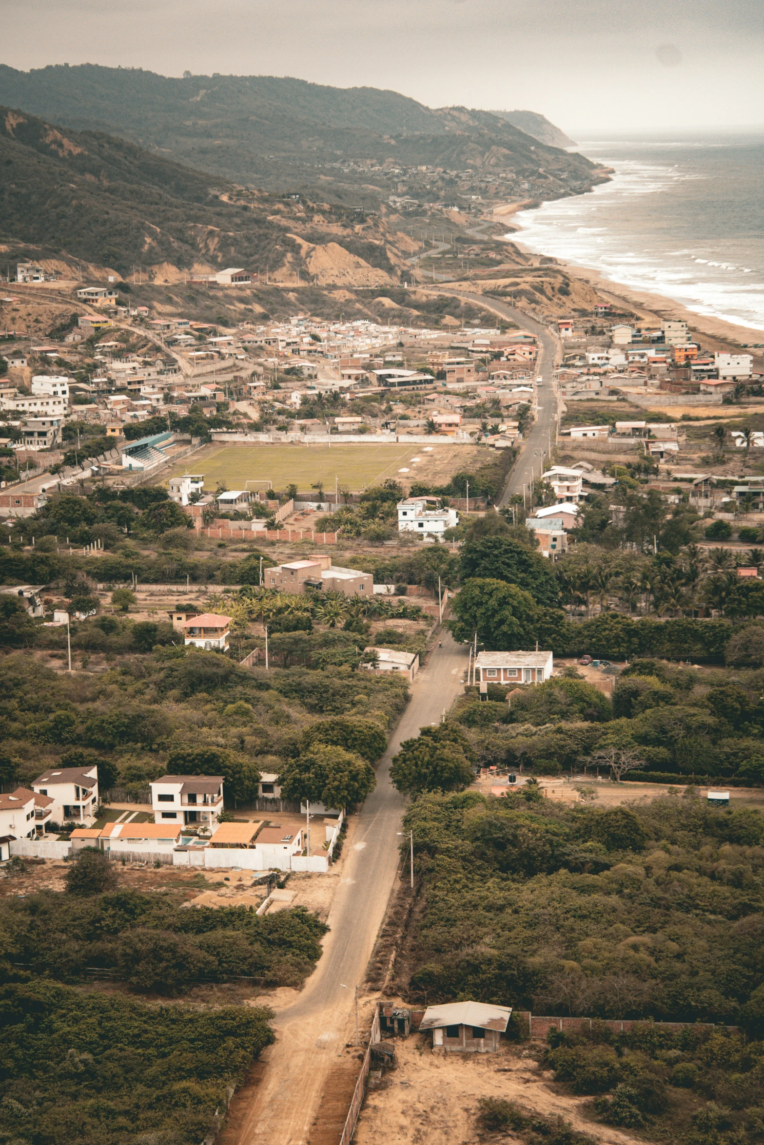 an aerial view of a long stretch of road by the ocean