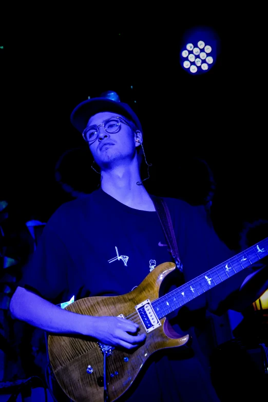 a man playing guitar in a dimly lit room