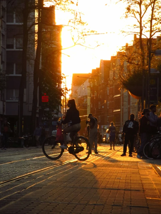 the bike rider is traveling down the busy sidewalk