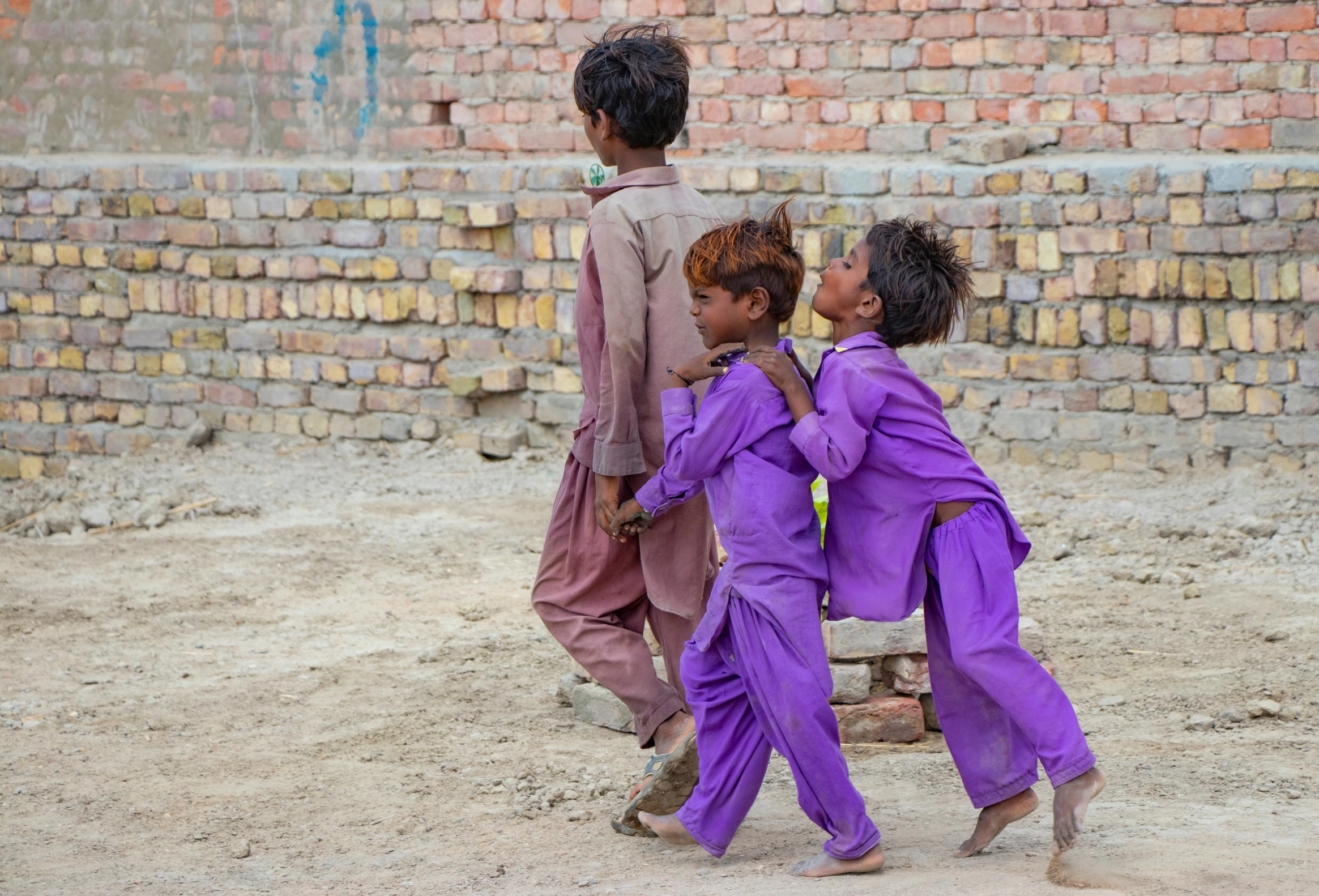 a group of people walking by a brick wall