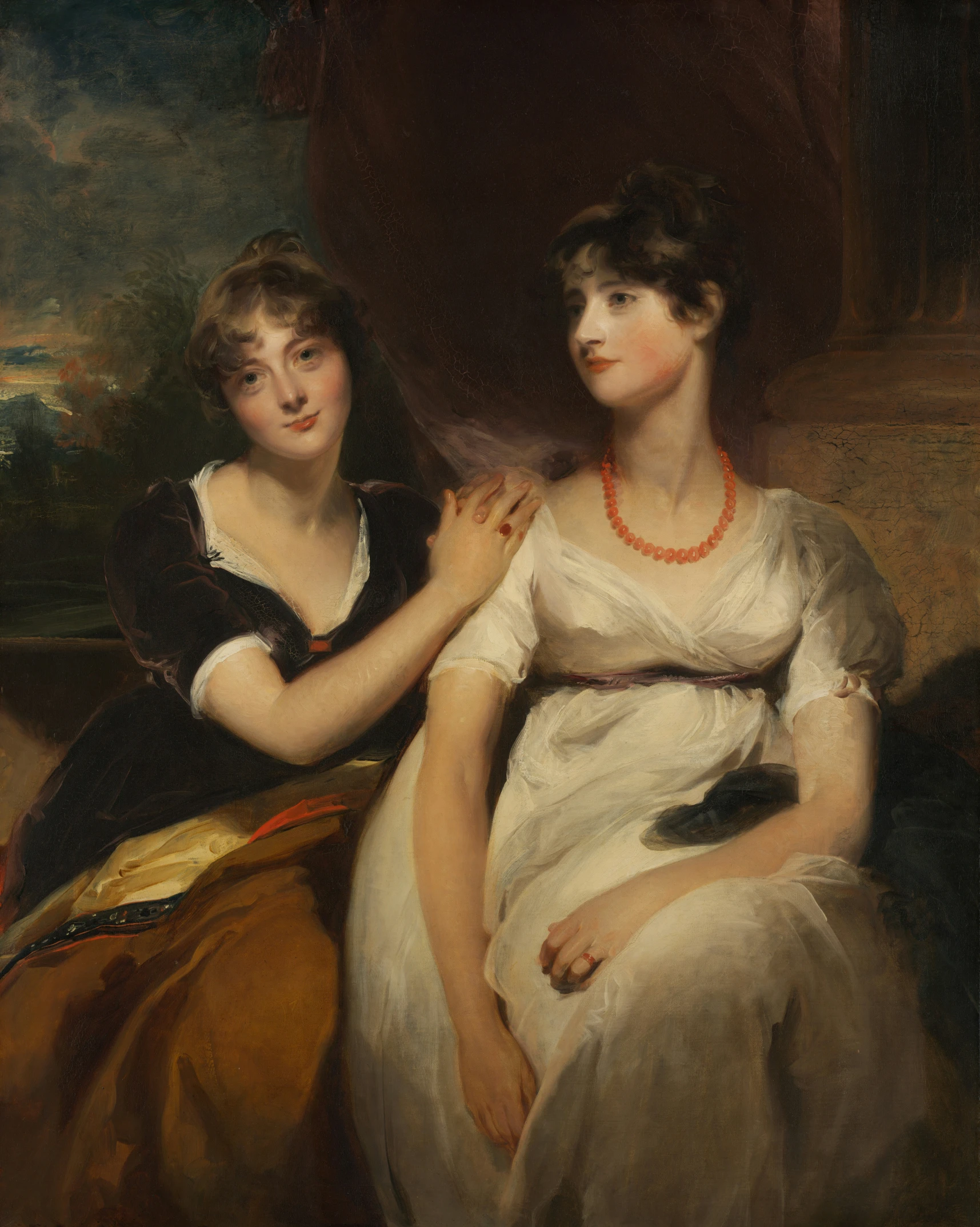 two women in white dresses are looking at a picture