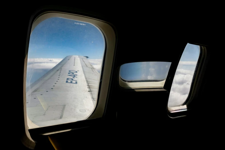 an airplane wing reflected in the window of another plane
