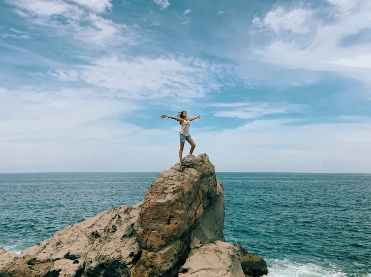 man standing on a rock in front of water