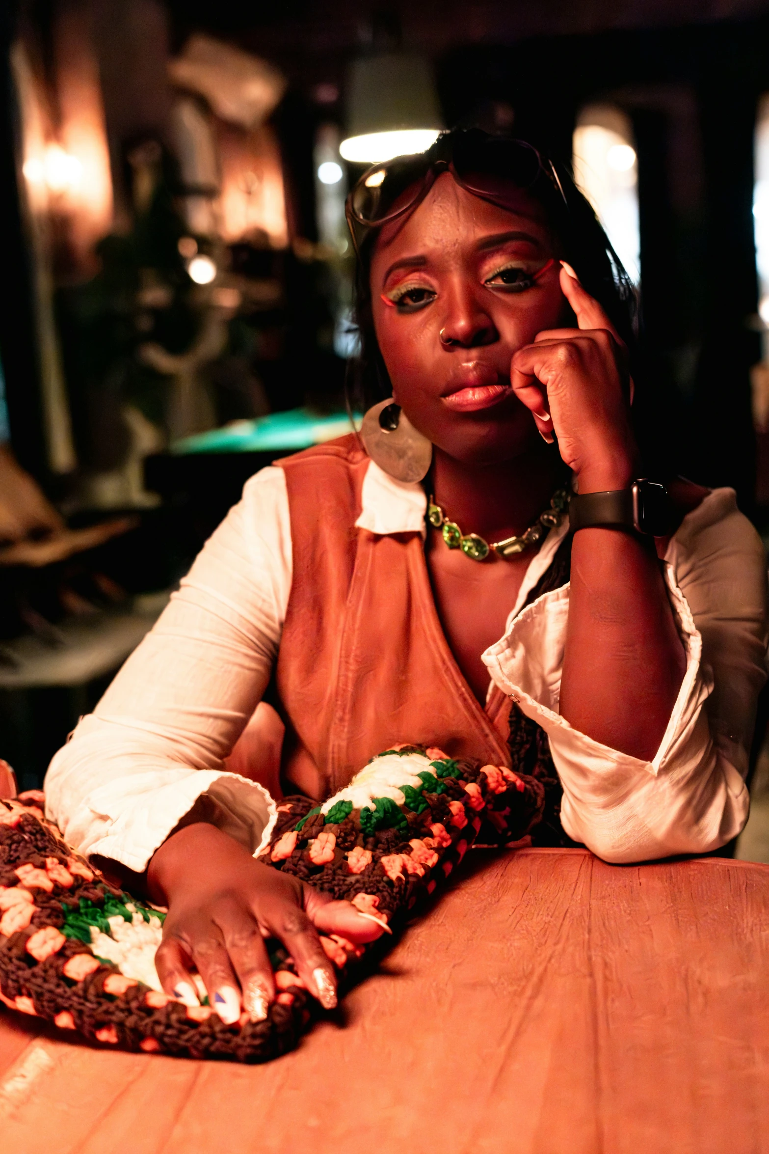 a woman sitting at a table talking on a phone