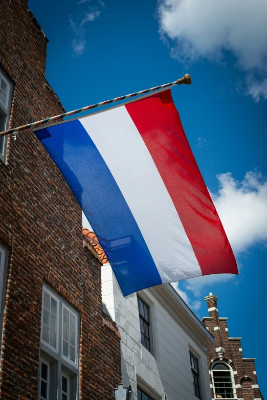 there is a big dutch flag hanging outside of a house