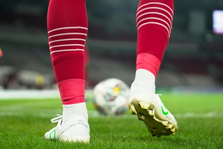 a close up po of a person kicking a soccer ball