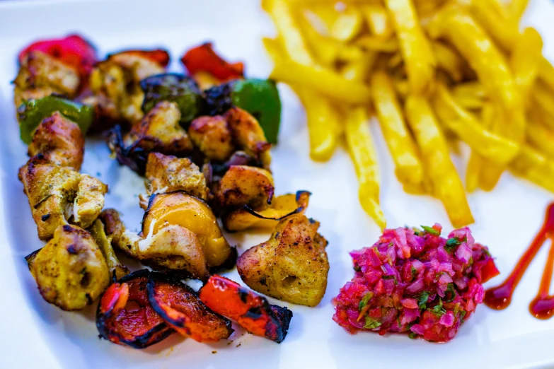 a white plate topped with chicken, vegetables and a side dish