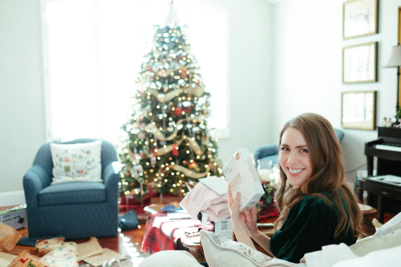 a woman smiles at the camera while reading a book