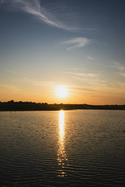 the sun is setting over water near a dock