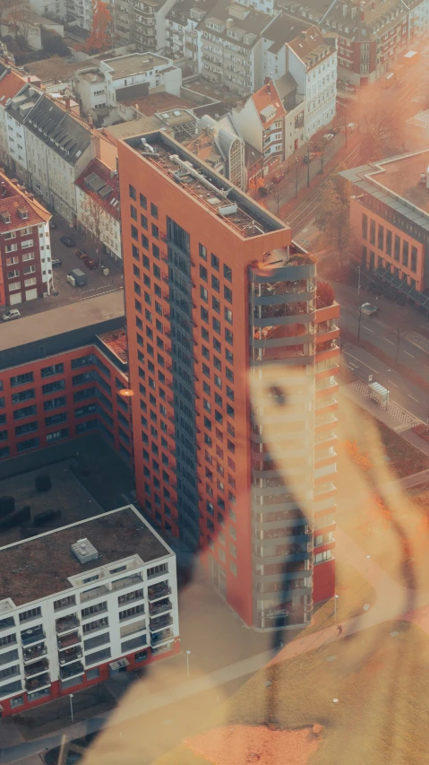 aerial view of two buildings, a person's hand, and a window