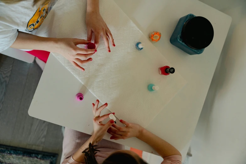 several people putting decorations on a table top