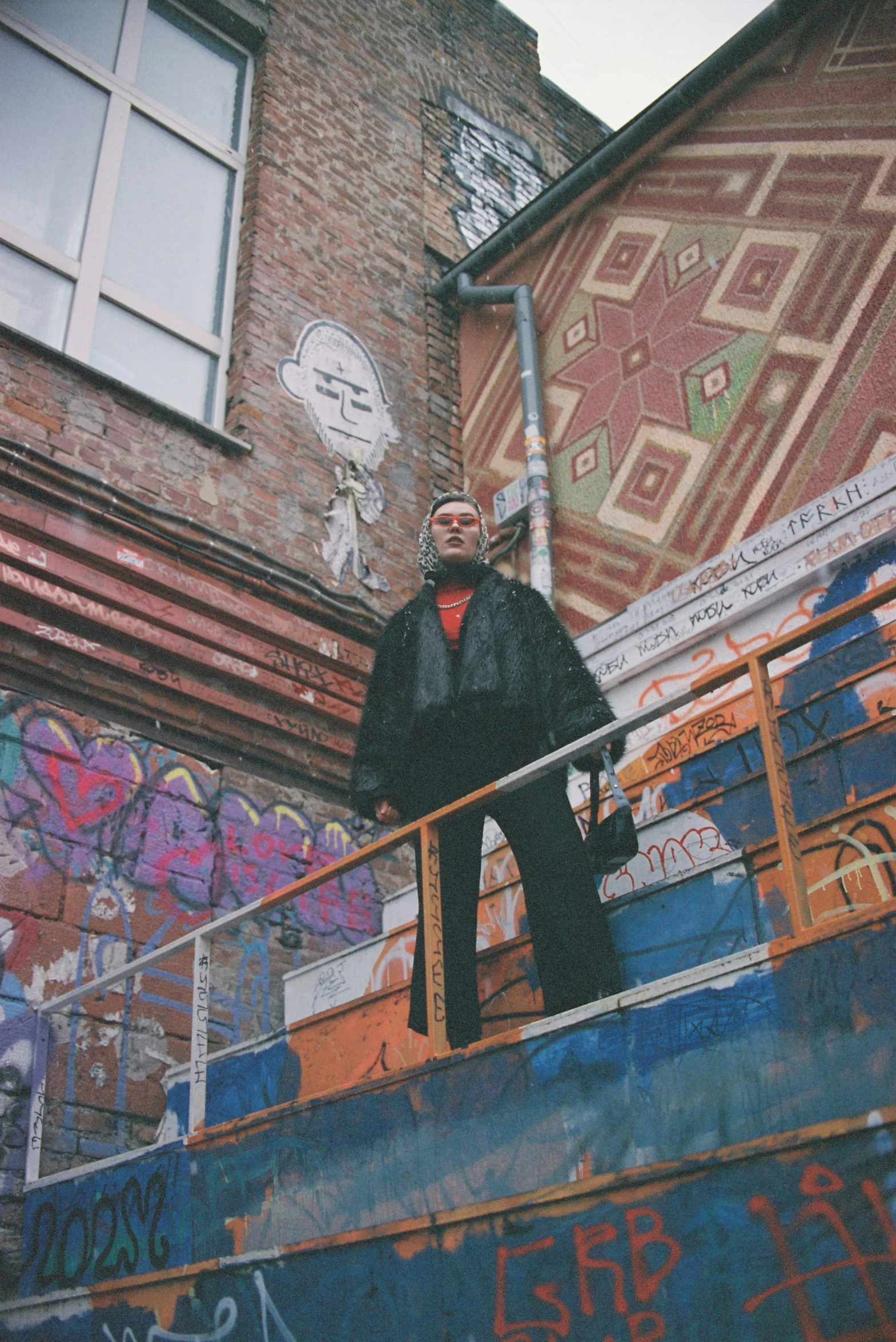 a graffiti covered stairwell area next to an old building