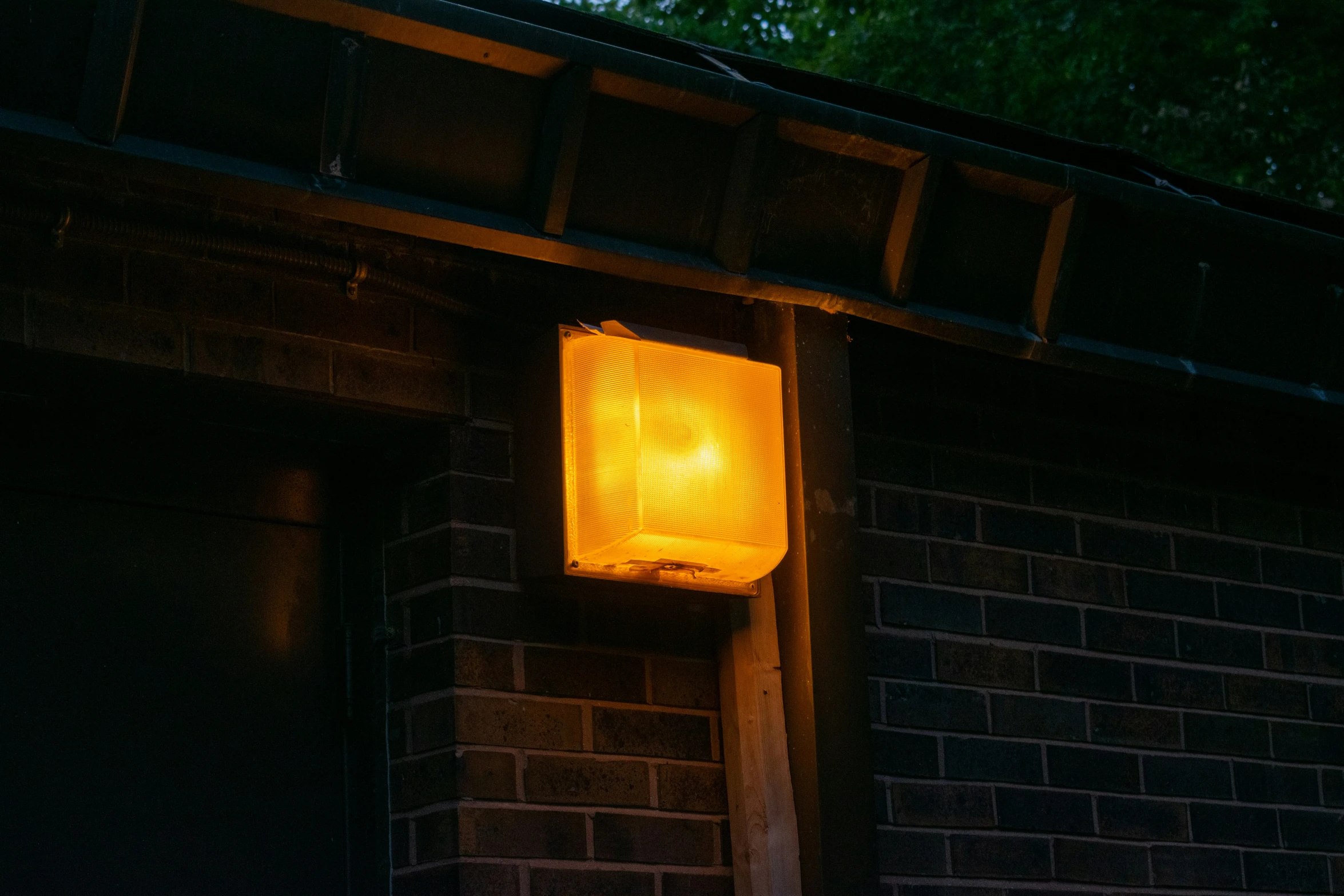 a yellow light that is on a brick wall