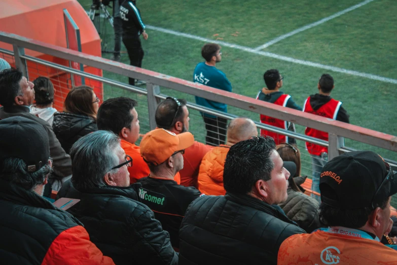 a crowd sitting on the side of a field