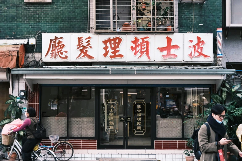 a street with people walking and sitting on benches in front of storefront