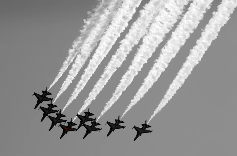 seven jets flying close together in formation in the sky