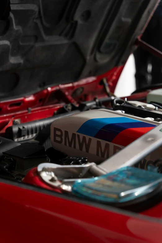 an assortment of parts sitting in the hood of a red car