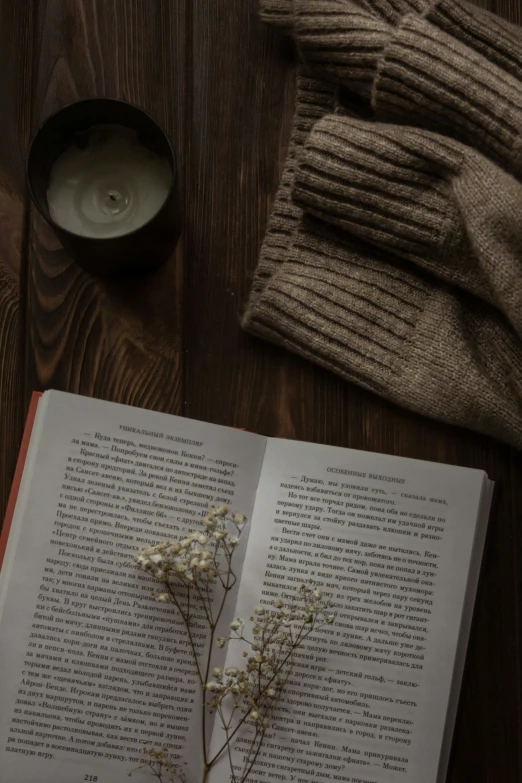 a book open next to an empty vase