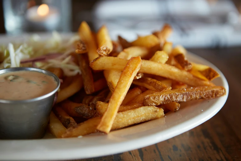 french fries on a plate with dipping sauce