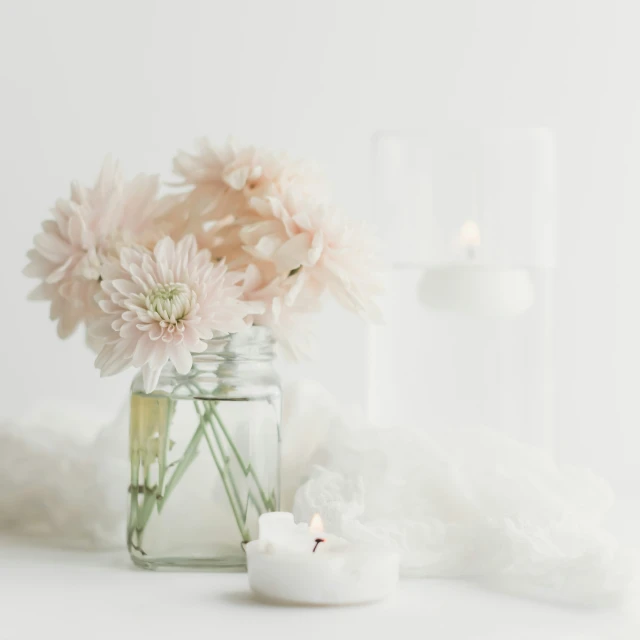 flowers and candles on a white background in a jar