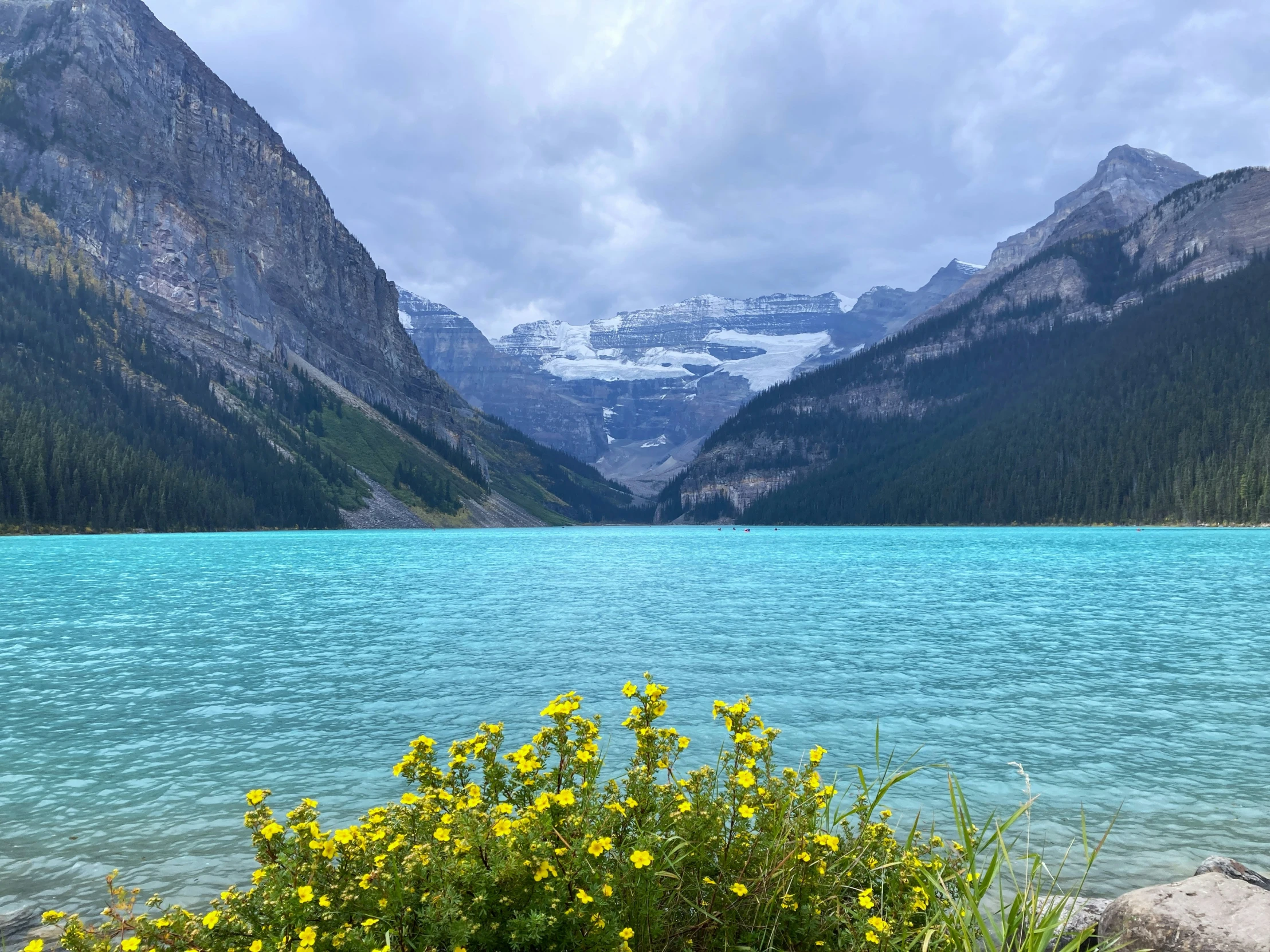 the blue water is surrounded by rocky mountain peaks