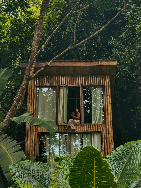 a wooden hut sits on stilts in the woods