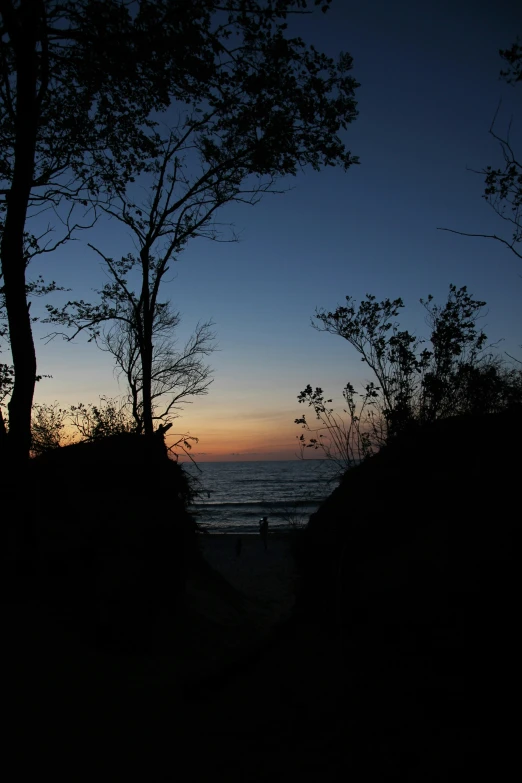 there are people on the beach at sunset