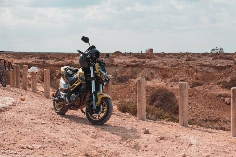 the motorcycle is parked near the wooden fence