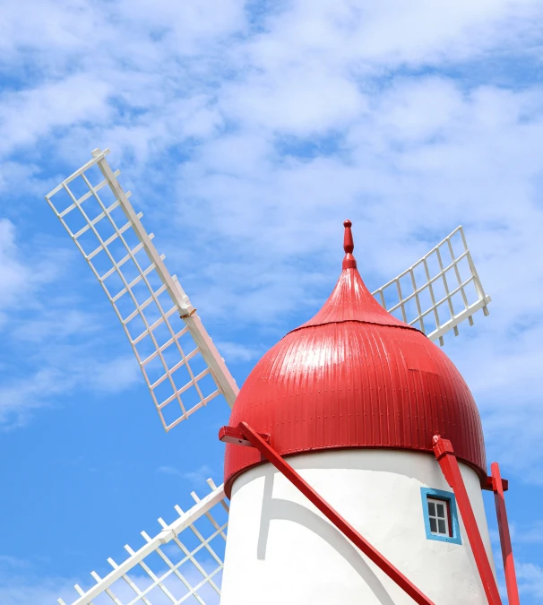 a red and white striped windmill against a blue sky