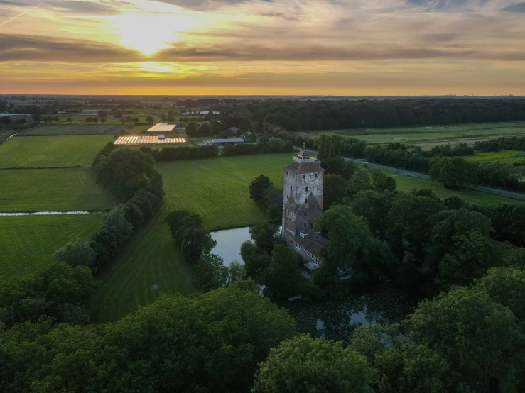 a large tower next to some trees on a field