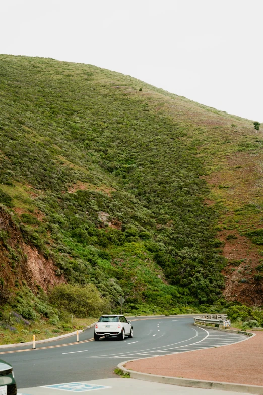 there are cars driving down a winding mountain street