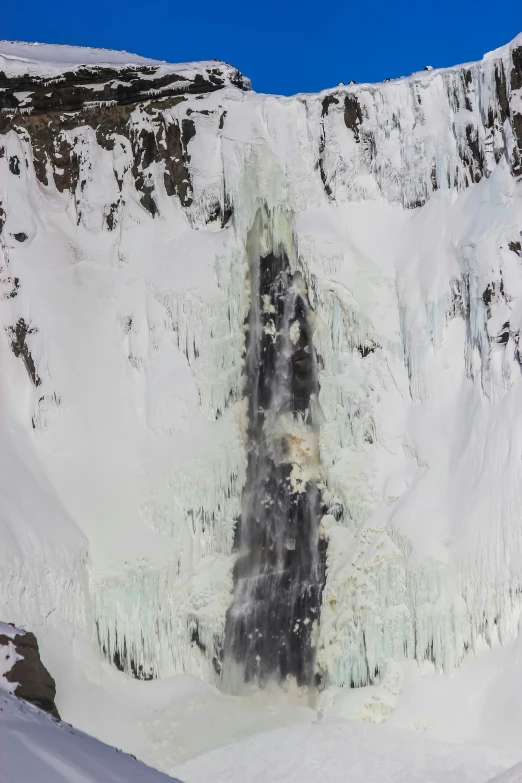 an artistic snow scene of frozen waterfall with sky above