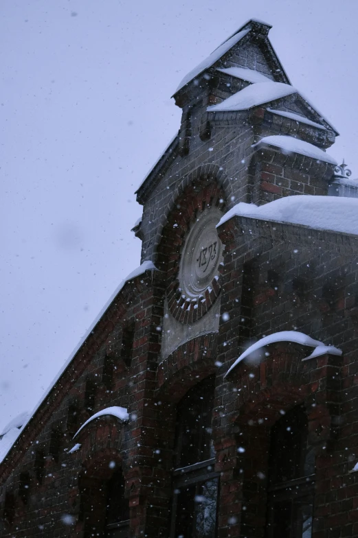 a clock tower with snow falling from it